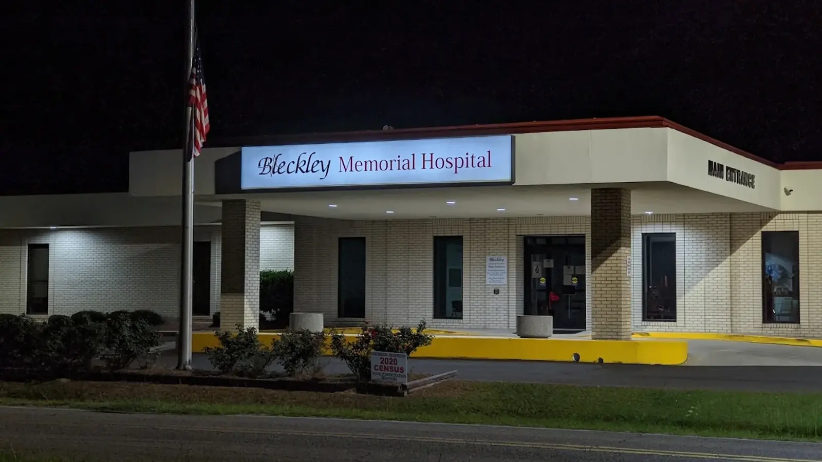 Bleckley Memorial Hospital main entrance at night, the illuminated sign lit above the covered drive